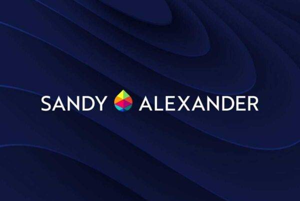 White text reading Sandy Alexander with a colorful geometric logo between the words, set against a dark blue, abstract, layered background creates a bold and modern Sandy Alexander visual statement.